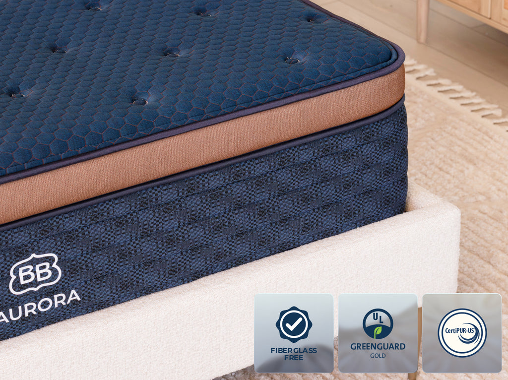Close-up of the Brooklyn Bedding Aurora Luxe Cooling mattress with Fiberglass Free, GREENGUARD Gold, and CertiPUR-US icons.